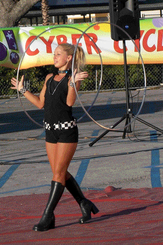 Ashley Winn performs with two silver hula hoops